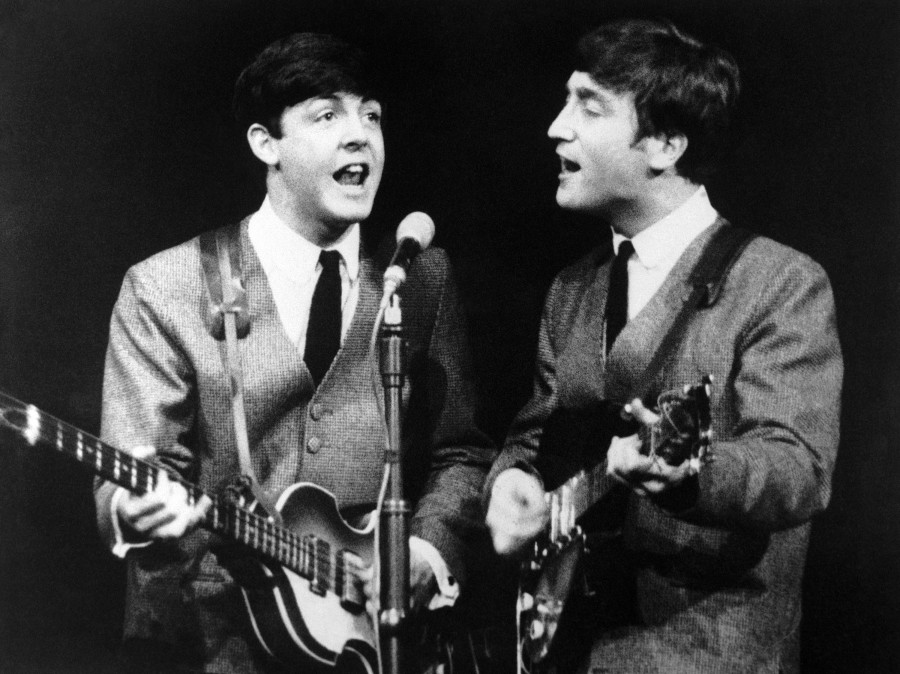 Paul McCartney, left, and John Lennon during a November 1963 Beatles show in London. The next month, the band had its first big hit in the U.S. and Beatlemania started to sweep America.